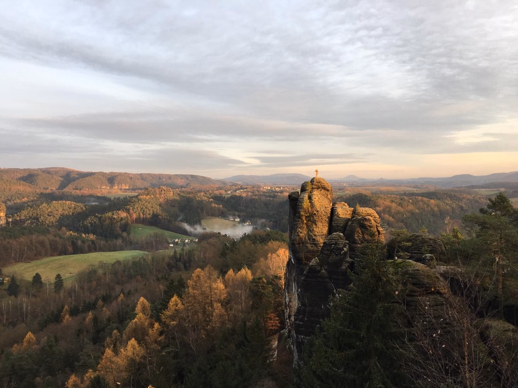The Brosinnadel, a sandstone pinnacle above Saxon Switzerland, with a climber at the summit